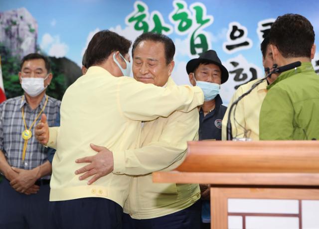 30일 오후 경북 군위군청에서 김영만 군위군수가 대구통합 신공항 이전지를 공동후보지로 신청할 것을 조건부 합의했다고 밝힌 후 권영진 대구시장과 껴안고 있다. 국방부 대구 군 공항 이전부지 선정위원회는 지난 3일 단독후보지(군위군 우보면)에 대해 부적합 결정을 내리고 공동후보지(군위군 소보면·의성군 비안면)는 오는 31일까지 적합 여부 판단을 유예한 상태다. 군위군은 그동안 단독후보지를 고수하다 이날 막판 협상 끝에 조건부로 공동후보지에 합의했다. 군위=연합뉴스