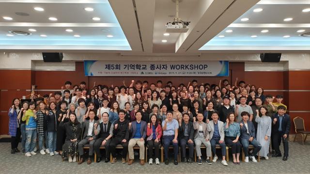 지난 해 9월 경주대명리조트에서 실시한 제5회 기억학교 종사자 WORKSHOP에서 참가자들이 파이팅을 외치며 단체 사진을 찍고 있다. 기억학교협회 제공