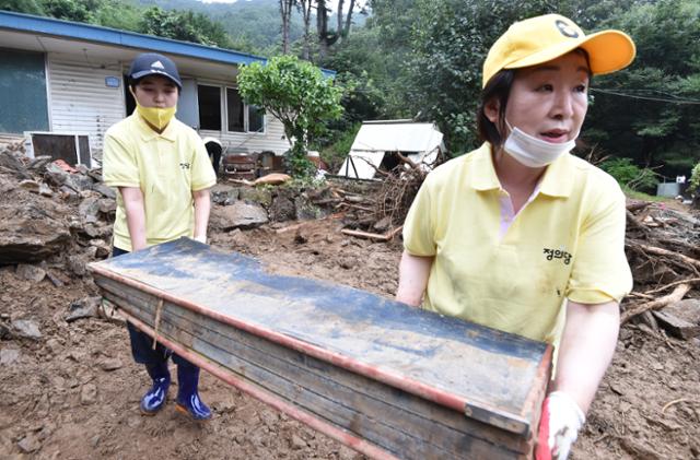 정의당 심상정 대표와 류호정 의원이 7일 경기 안성시 죽삼면 수해 현장을 찾아 복구 활동을 하고 있다. 심 대표는 페이스북에 이곳에서 의원, 당직자들과 찍은 기념 사진을 올렸다가 “인증샷 찍으려 갔느냐”는 당 안팎의 비판을 받고 사진을 삭제했다. 안성=뉴시스