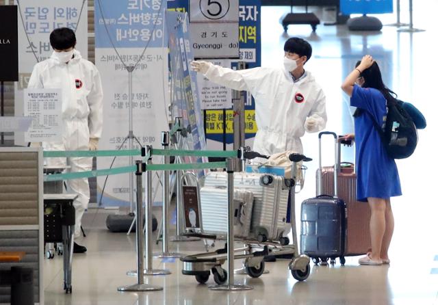 11일 오후 인천국제공항에서 한 입국객이 관계자의 안내를 받고 있다. 연합뉴스