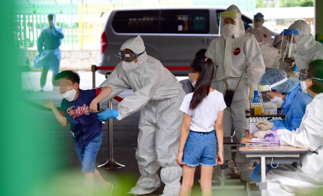 지난 달 18일 광주 한 초등학교에 설치된 선별진료소에서 방역당국이 전 학생을 대상으로 검사를 하고 있다. 뉴시스