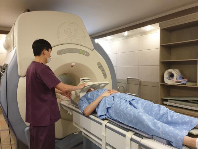 서울 서초구 한신메디피아에서 의료진이 수검자의 뇌 자기공명영상(MRI) 촬영을 준비하고 있다. 이곳에선 뇌 MRI 촬영 후 사진을 인공지능 기술로 분석해 노화 정도를 알려주는 검진 서비스를 운영한다. 한신메디피아 제공