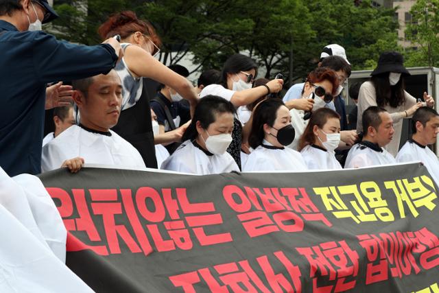 인천국제공항공사노동조합 조합원들이 13일 오전 서울 중구 예금보험공사 앞에서 열린 '졸속 정규직화 규탄 및 해결책 마련 촉구 집회'에서 삭발식을 진행하고 있다. 뉴스1