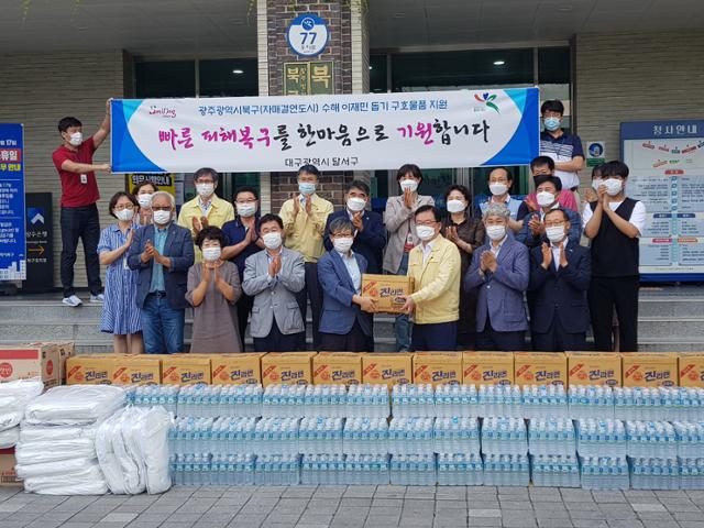 14일 오후 광주 북구청사 앞에서 대구 달서구 관계자 등이 수해 피해를 입은 이재민들을 돕기 위한 구호물품을 싣고 와 문인 북구청장에게 전달하고 있다. 북구 제공