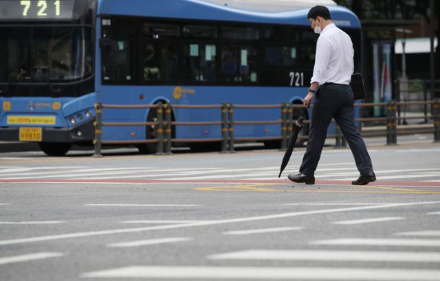 장맛비가 일시 소강 상태를 보인 지난 13일 오전 서울 종로구 광화문광장에서 한 시민이 우산을 들고 출근 하고 있다. 뉴시스