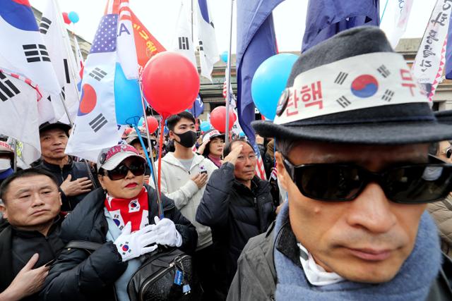 지난해 3월 '박근혜 탄핵 2년'을 앞두고 서울 중구 서울역 광장에서 열린 제112차 태극기 집회에서 참석자들이 국민의례를 하고 있다. 뉴스1