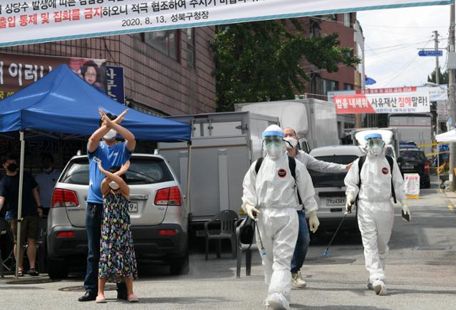 신종 코로나 집단감염이 서울 성북구 사랑제일교회에 발생한 가운데 16일 방역 관계자들이 교회 주변에 대해 방역을 시작하자 교인들이 나와 손으로 'X를 그리며 항의하고 있다. 서재훈 기자