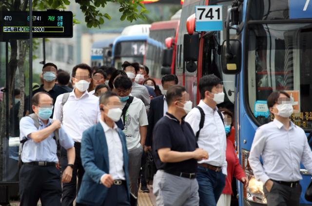 서울 중구의 한 버스 정류장에서 마스크를 쓴 시민들이 출근을 서두르고 있다. 연합뉴스