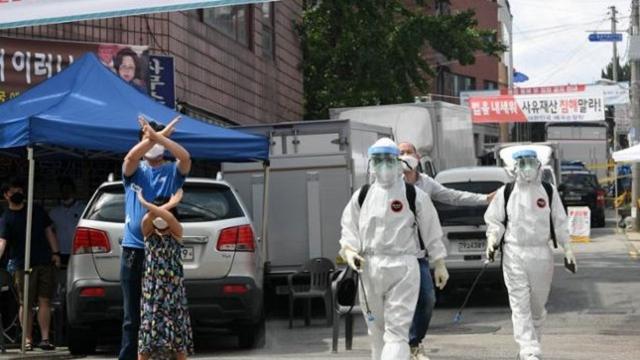 코로나19 집단감염이 서울 성북구 사랑제일교회에 발생한 가운데 16일 방역 관계자들이 교회 주변에 대해 방역을 시작하자 교인들이 나와 손으로 'X를 그리며 항의하고 있다. 연합뉴스