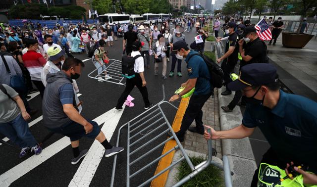 광복절 집회 참가자들이 지난 15일 오전 서울 종로구 광화문광장에서 경찰이 세워놓은 바리게이트를 넘어 도로로 나오고 있다. 뉴시스