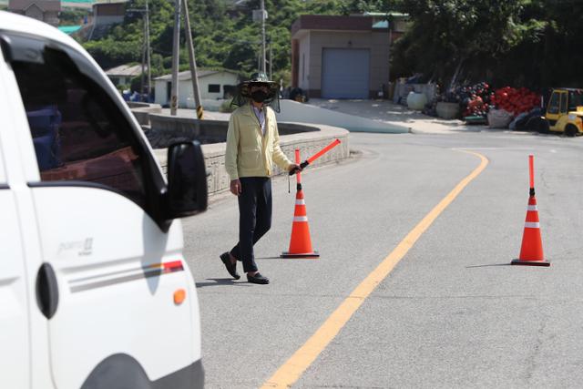 18일 오후 전남 진도군 임회면 한 마을의 유일한 길목에서 공무원이 코로나19 확산 우려 탓에 외부인 방문을 통제하고 있다. 연합뉴스