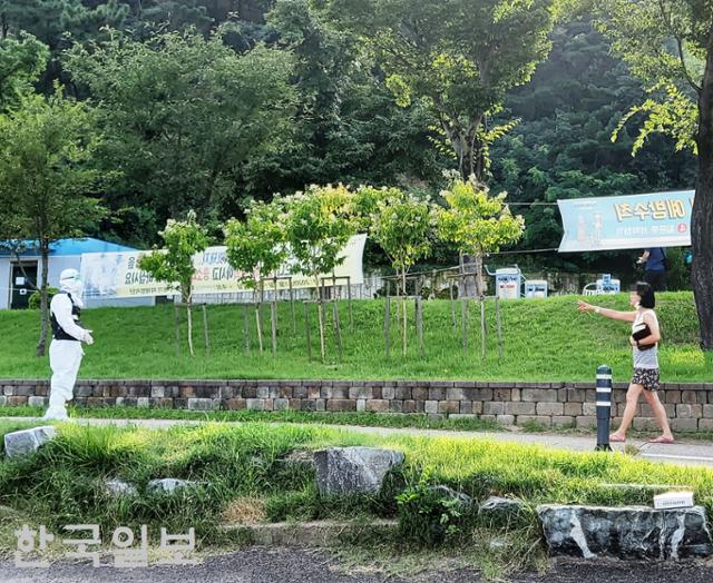 경북 포항에서 병원 이송 직전 도주한 신종 코로나바이러스 감염증 환자가 17일 포항의 한 공원에서 발견된 후 항의하며 경찰과 대치하고 있다. 한국일보 자료사진 (무단전재 및 재배포 금지)