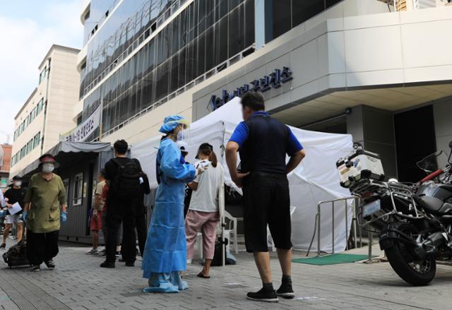 19일 사랑제일교회 소재지인 서울 성북구의 보건소에 마련된 선별진료소에서 시민들이 신종 코로나바이러스 감염증(코로나19) 검사를 받기 위해 줄을 서고 있다. 뉴스1