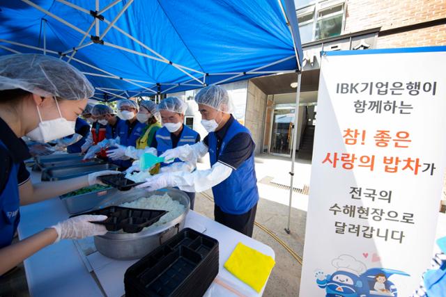 19일 충북 영동군에서 IBK기업은행 임직원 자원봉사단이 ‘사랑의 밥차’ 무료급식 봉사활동을 하고 있다. IBK기업은행 제공