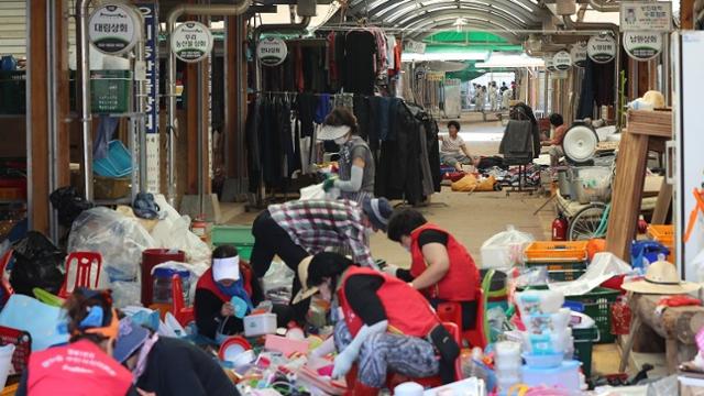 지난 17일 오전 전남 구례군 구례읍 오일시장에서 상인과 자원봉사자들이 상점의 물건을 정리하고 있다. 연합뉴스