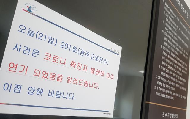 전주지방법원에 근무하는 한 판사의 신종 코로나바이러스 감염증 확진이 확인된 21일 전북 전주시 전주지법에 재판 중단 안내문이 붙어 있다. 전주=뉴스1