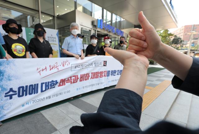 25일 서울 중구 인권위원회 앞에서 열린 국가인권위원회 앞에서 열린 수어에 대한 왜곡과 비하 재발방지를 촉구하는 차별진정 기자회견에서 농인들이 수어를 하며 의료인들의 덕분이라며 챌린지에 대한 사과를 요구하고 있다. 뉴스1