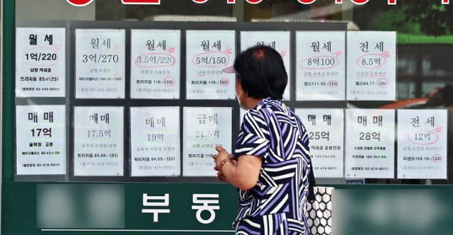 한 시민이 20일 서울시내 한 부동산 공인중개사 사무소에 붙은 매물 전단을 살펴보고 있다. 뉴스1