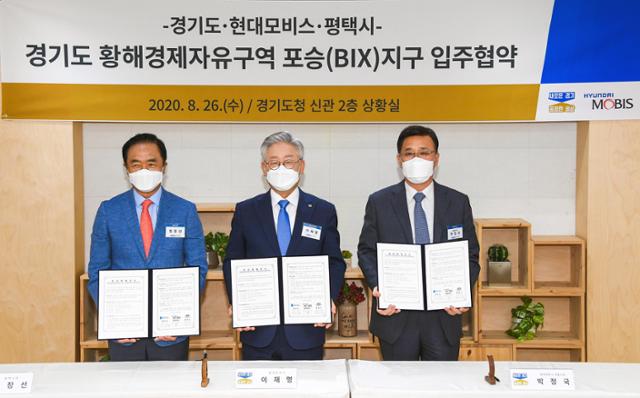 26일 경기도청에서 열린 현대모비스 전기차 핵심부품 공장설립을 위한 황해경제자유구역 입주협약식. 정장선(왼쪽) 평택시장, 이재명(중간) 경기도지사, 박정국(오른쪽) 현대모비스 사장 . 현대모비스 제공