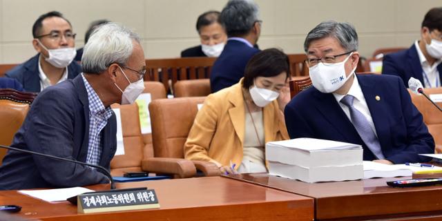 이재갑(오른쪽) 고용노동부 장관과 문성현 경제사회노동위원회 위원장이 지난 21일 오전 국회에서 열린 환경노동위원회 전체회의에서 대화하고 있다. 연합뉴스