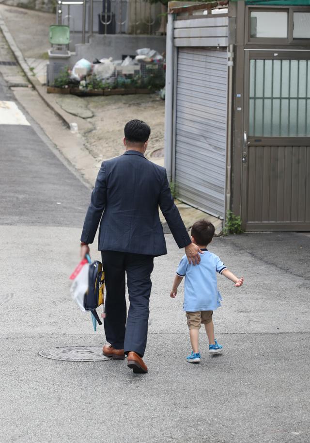 사회적 거리두기가 2단계로 격상됨에 따라 어린이집 개원이 연기된 지난 18일 오후, 서울의 한 어린이집에서 부모가 아이를 데리고 나오고 있다. 뉴스1