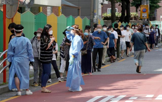 보성운수 시내버스 기사 3명이 코로나19 확진 판정을 받은 가운데 24일 오전 서울 구로구 보건소에 마련된 선별진료소를 찾은 시민들이 줄을 서 기다리고 있다. 뉴시스