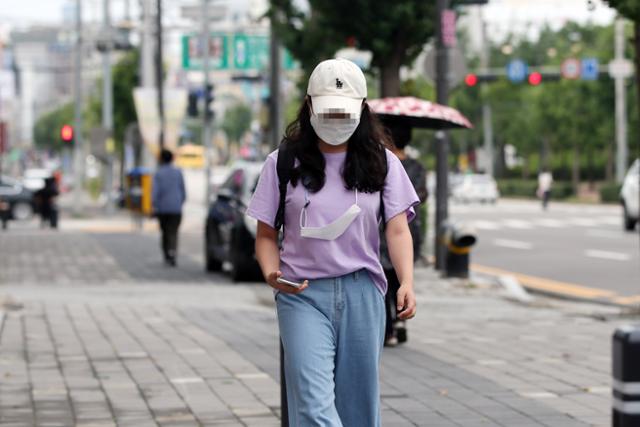 코로나19 재확산 공포가 급증하고 있는 27일 광주 두암동의 거리에서 마스크를 쓴 시민이 여분의 마스크를 목에 건 채 길을 걷고 있다. 광주=연합뉴스