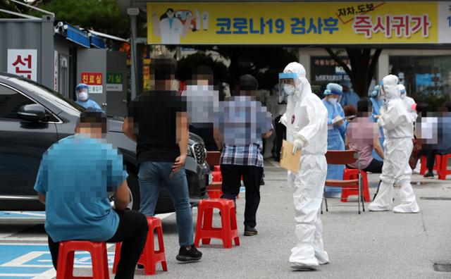 신종 코로나바이러스 감염증이 확산하고 있는 27일 광주 동구보건소 선별진료소에 코로나19 검사를 받으려는 시민들이 줄지어 앉아 있다. 광주=연합뉴스