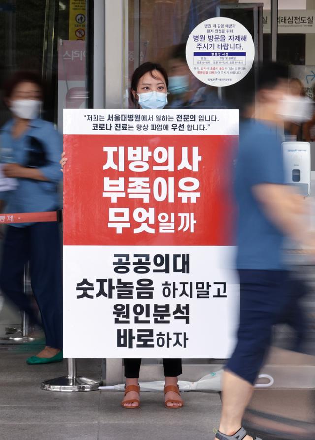 정부의 보건의료정책에 반대하는 대한의사협회의 집단휴진 이틀째인 27일 서울 종로구 서울대학교병원 본관 앞에서 한 전문의가 팻말을 든 채 1인 시위를 하고 있다. 연합뉴스