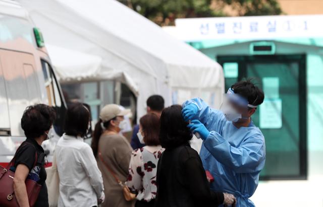 제8호 태풍 '바비'의 영향으로 수도권 등의 선별진료소가 임시 운영 중단됐다 다시 진료를 시작한 지난 27일 서울 중구의 한 선별진료소를 찾은 시민이 검사를 받기 위해 줄을 서고 있다. 뉴시스