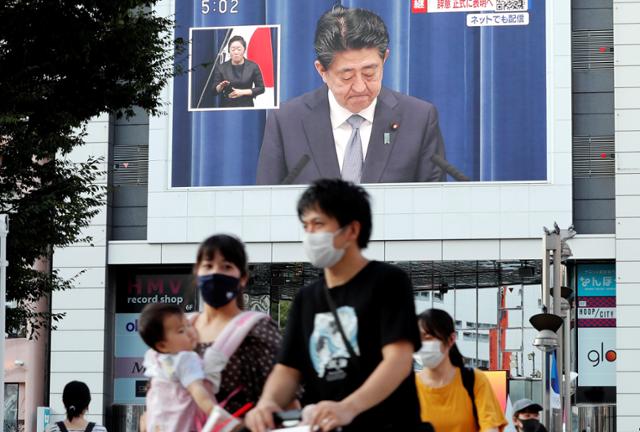 28일 오후 일본 도쿄시내 대형 전광판에 아베 신조 총리의 사의 표명 기자회견이 생중계되고 있다. 일본 언론들은 앞서 아베 총리의 사의 표명 소식을 긴급 타전하고 호외를 발행했다. 도쿄=로이터 연합뉴스