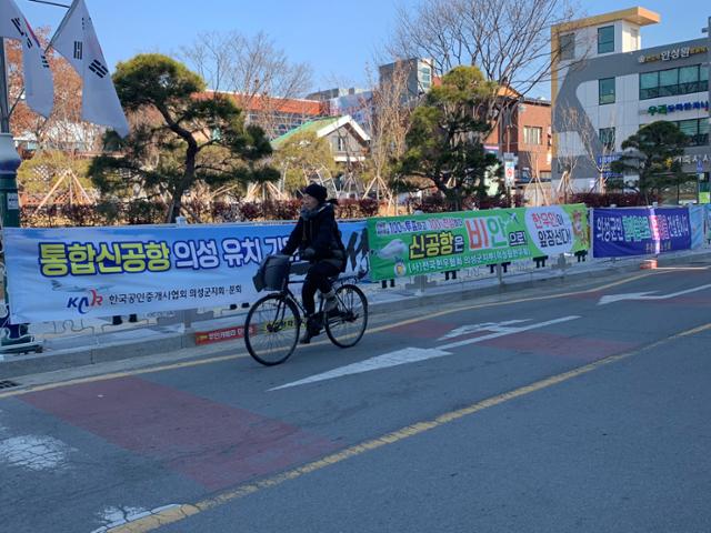 한 의성 주민이 지난 1월 의성군청 앞에 설치된 통합신공항 의성 유치 기원 현수막을 보며 자전거를 타고 지나가고 있다. 한국일보 자료사진