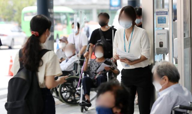 전국의사 2차 총파업(집단휴진) 이틀째인 27일 오후 서울 종로구 서울대병원 출입문 앞에서 전공의들이 의대정원 확대 등 정부의 의료정책을 반대하는 홍보물을 방문객들에게 나눠주고 있다. 뉴스1