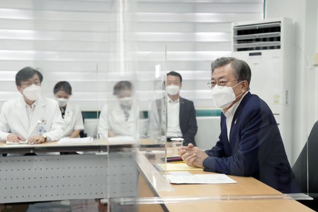 문재인 대통령이 28일 서울 중구 국립중앙의료원 수도권 병상 공동대응 상황실을 방문, 신종 코로나바이러스 감염증(코로나19) 현장대응 보고를 받은뒤 의견을 나누고 있다. 청와대사진기자단