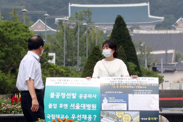 서울대병원 소속 전문의가 30일 서울 광화문 광장에서 의대 정원 확대 등 정부의 보건의료정책에 반대하는 1인 피켓 시위를 하고 있다. 이날 대한전공의협의회는 전국 수련병원 전공의 대표자 긴급비상대책위원회 의결 결과에 따라, 집단휴진을 지속하기로 했다고 밝혔다. 뉴스1