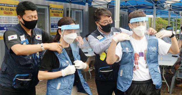 전주시자원봉사센터 관계자들은 31일 전북 전주시 화산체육관에 마련된 신종 코로나바이러스 감염증(코로나19) 대응 선별 진료소를 방문해 무더위에 지친 의료진들에게 냉방 조끼를 전달하고 있다. 전주=뉴시스