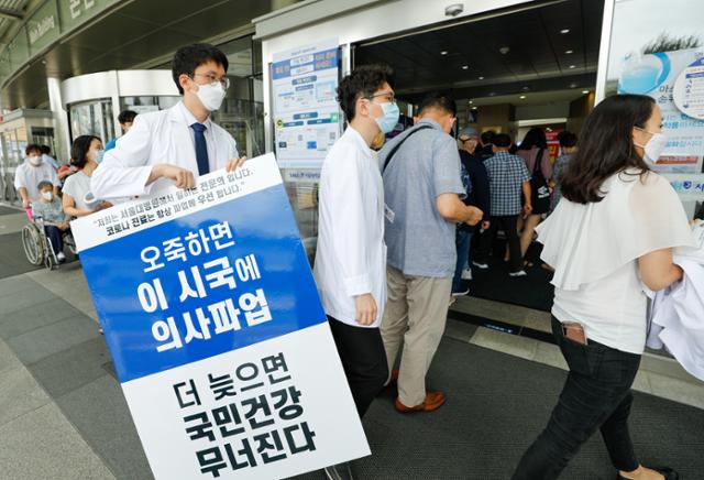 전공의들이 무기한 파업을 지속하기로 한 31일 서울 종로구 서울대병원 본관 앞에서 전문의들이 정부가 추진하고 있는 의대 정원 확대, 공공의대 설립 등을 반대하며 1인 피켓 시위를 하기위해 이동하고 있다. 서울대병원은 전공의, 전임의 파업으로 교수들의 진료부담이 과중해지자 이날부터 일주일간 내과 외래진료를 축소하기로 했다. 뉴스1