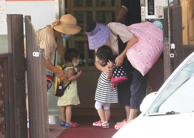 지난달 25일 서울 종로구의 한 국공립어린이집에서 할머니들이 손주들을 긴급돌봄교실에 등원 시키고 있다. 사회적 거리두기 2단계가 적용되면 어린이집은 휴원에 들어가지만, 돌봄교실은 그대로 운영된다. 뉴스1