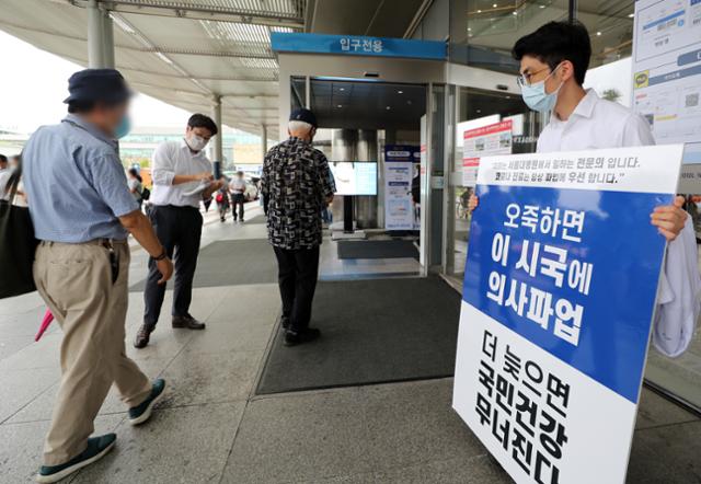 2일 오전 서울 종로구 서울대병원 본관 앞에서 전공의가 정부의 의료정책을 반대하는 내용이 적힌 피켓 시위와 유인물을 나눠주고 있다. 의료계에 따르면 서울대 의대 교수들이 정부의 전공의 고발조치 등에 대응하기 위해 비상대책위원회 출범을 논의하고 있는 것으로 알려졌다. 뉴스1