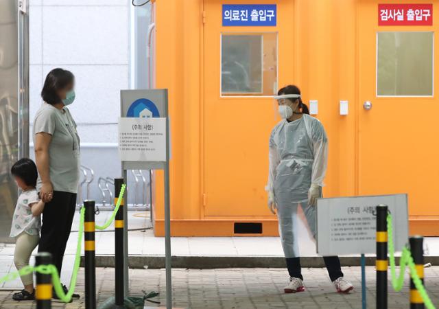 대구 북구 칠성동 동우빌딩 지하에서 열린 동충하초 사업설명회 참석자 관련 신종 코로나바이러스 감염증(코로나19) 확진자가 30명으로 늘어난 가운데 4일 오후 아이가 엄마와 함께 대구 북구보건소 선별진료소를 찾았다. 뉴스1