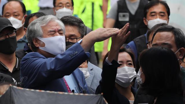 보석 취소로 재수감되는 전광훈 목사가 7일 오후 성북구 사랑제일교회 앞에서 기자회견 전 자신을 가리던 파라솔과 우산을 치우라는 손짓하고 있다. 연합뉴스