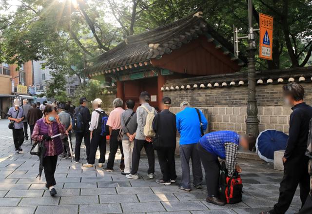 신종 코로나바이러스 감염증(코로나19)가 장기화 되면서 문을 닫는 무료급식소가 늘어나고 있는 가운데 10일 오전 서울 종로구 원각사 무료급식소 앞에서 어르신들이 주먹밥을 받기 위해 줄지어 서 있다. 뉴스1