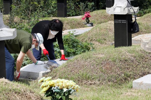 10일 오후 신종 코로나바이러스 감염증(코로나19) 사태로 추석 연휴 기간 문을 열지 않는 인천 부평구 인천가족공원을 미리 찾은 한 부부가 묘소를 청소하고 있다. 뉴시스