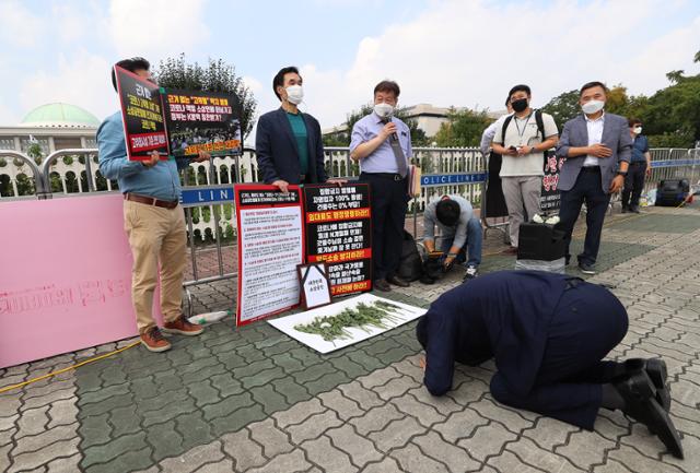 10일 오후 국회 앞에서 수도권 노래방 업주들이 고위험 시설 기준 전면 재검토와 임대료 문제 해결을 촉구하며 소상공인 영정 앞에 헌화한 뒤 절을 하고 있다. 연합뉴스