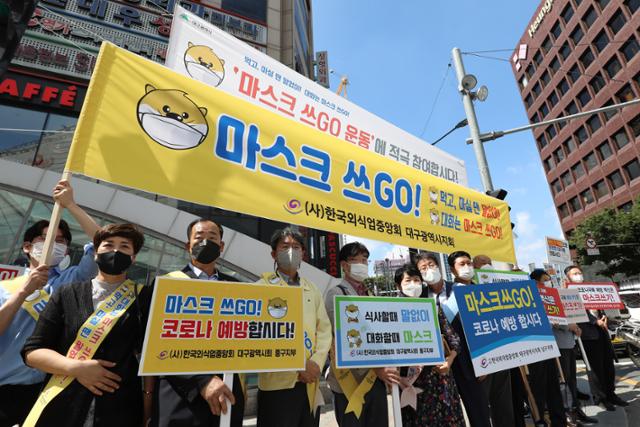 한국외식업중앙회 대구지회 회원들이 14일 대구 중구 대구도시철도 중앙로역 지상 중앙네거리에서 '마스크 쓰GO!' 운동 캠페인을 펼치고 있다. 대구시는 마스크 쓰기가 코로나19 감염을 막는 효율적인 방역 대책이라고 보고 먹고 마실 땐 말없이, 대화는 마스크를 쓰고 하자는 마스크 쓰GO 운동을 전개하고 있다. 뉴스1