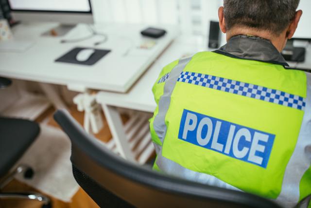 경찰 이미지 Senior British traffic warden using computer at the office. 게티이미지뱅크