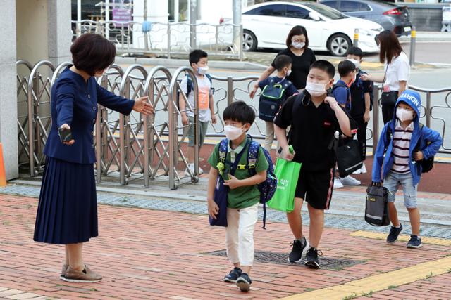 광주지역 각급 학교가 원격수업에서 부분 등교수업으로 전환한 14일 오전 광주 광산구 선암동 한 초등학교에서 교장 선생님이 학생을 맞이하고 있다. 연합뉴스