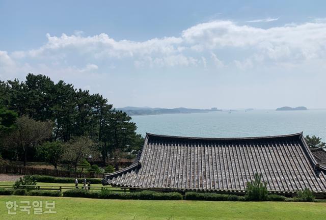 상화원 한옥마을의 기와지붕 너머로 서해바다와 무창포해수욕장이 보인다.