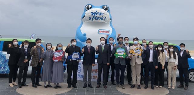 16일 부산 해운대해수욕장 광장에서 진행된 하이트진로의 차량 기증식에서 김인규(왼쪽에서 여덟번째) 하이트진로 대표와 홍순헌(왼쪽에서 일곱번째) 해운대구청장, 부산지역 사회복지기관 관계자 등이 참석해 기념사진을 찍고 있다. 하이트진로측은 장애인용 특수개조차량을 포함해 총 8대의 차량을 전국 사회복지기관에 기증했다. 하이트진로측은 지난 2015년부터 이어온 이 사회공헌활동을 통해 지금까지 총 38대 차량을 장애인들을 위해 제공했다. 하이트진로 제공