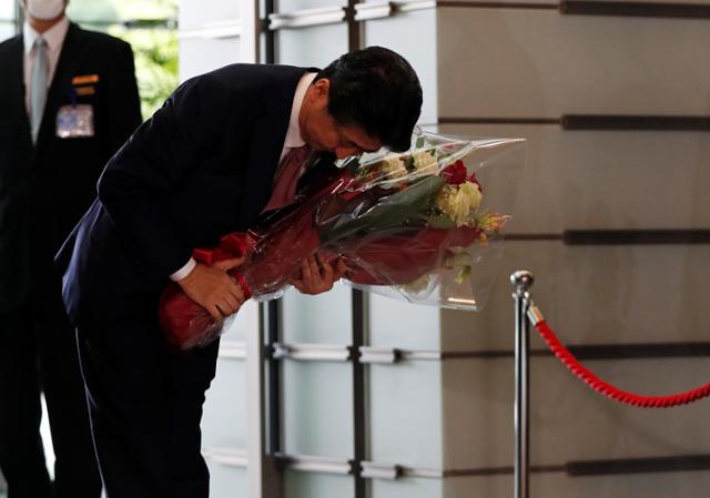 16일 퇴임한 아베 신조(安倍晋三) 일본 총리가 공관을 나서기 전 고개 숙여 인사하고 있다. 아베 총리와 내각은 이날 오전 임시 각의를 열고 총사퇴했으며 아베 정권의 계승을 표방하는 스가 요시히데 총리 내각이 공식 출범한다. 로이터 연합뉴스